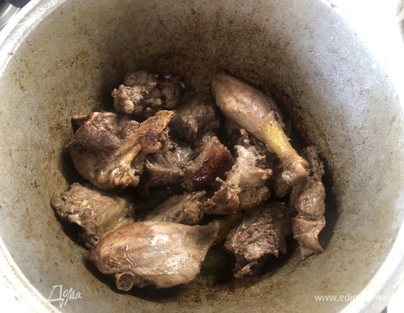 В казане нагрейте масло, обжаривайте утку в течение 20 минут.