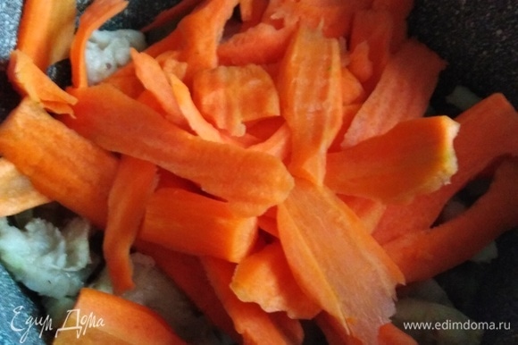 К рыбе отправляем нарезанную морковь, жарим 5 минут.