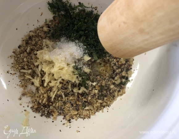 Переложите орехи в кастрюлю. Подавите или натрите мелко чеснок, нарежьте укроп, добавьте неполную чайную ложку соли и 2 ст. л. оливкового масла, хорошо перетрите все скалкой.