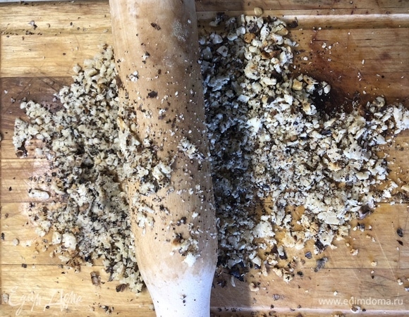 В сухой сковороде обжарьте орехи, переложите на доску, подавите скалкой.