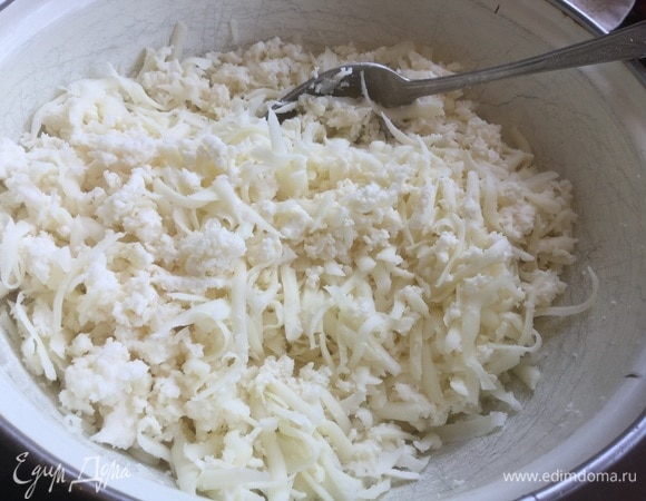 Сыр натрите на терке, добавьте колотый лед (или ледяную воду) и рубленое сливочное масло, разомните рукой до получения сырной кашицы.