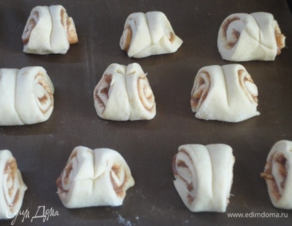 Выложить булочки на противень, застеленный пергаментом, сохраняя интервал между ними, и оставить на 30 минут подходить. Разогреть духовку до 200°C. Подошедшие булочки смазать яйцом и посыпать жемчужным сахаром, которого у меня не оказалось. Я посыпала обыкновенным сахаром.