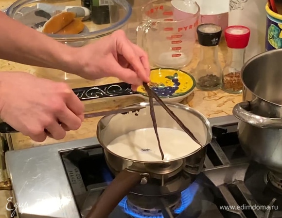 Молоко влить в сотейник и довести почти до кипения, стручок ванили разрезать, вынуть зерна и добавить в молоко.