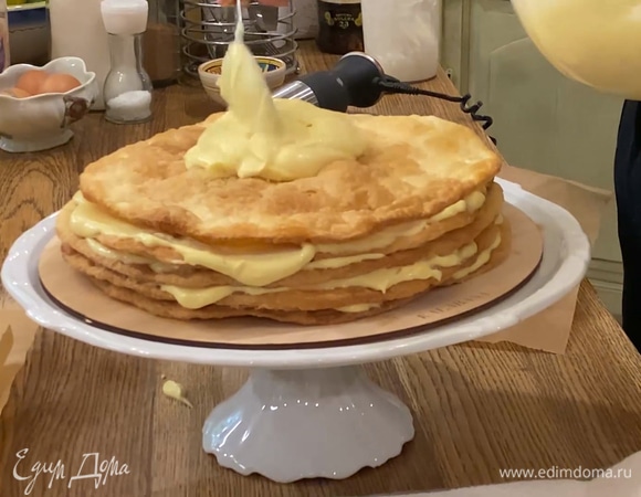 Уложить 7 коржей один на другой, промазывая их кремом, затем срезать у торта неровные края.