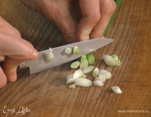 Зеленый лук тонко нарезать наискосок и посыпать крылышки.