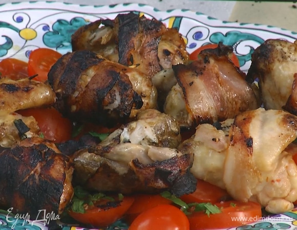 Готовые крылышки выложить на помидоры, посыпать зеленью, полить оставшимся оливковым маслом Extra Virgin.