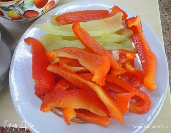 Перцы запечь в духовке при 200°C, пока кожура не припечется. Положить в пластиковый мешок, дать слегка остыть и затем очистить от кожуры, которая легко отойдет. Нарезать полосками.