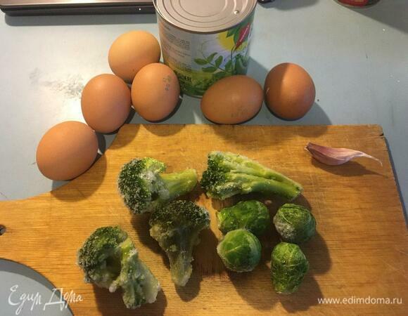 Подготовим ингредиенты. Брокколи и брюссельскую капусту достать из морозильника, чеснок очистить и мелко нарезать. Из банки с консервированным горошком слить жидкость. У меня была банка 400 г, в списке ингредиентов указан вес без жидкости.