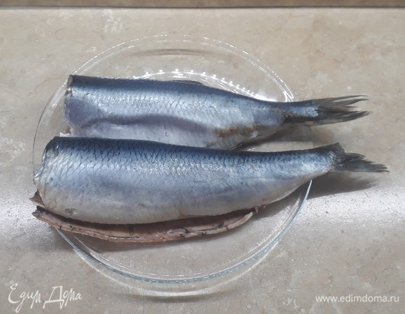 В это время размораживаю сельдь и разделываю: мою, отрезаю голову, убираю внутренности и черную пленку (если есть икра, перекладываю ее в пиалу и посыпаю солью, через несколько часов она готова). Хвосты я оставляю, но можно и отрезать.