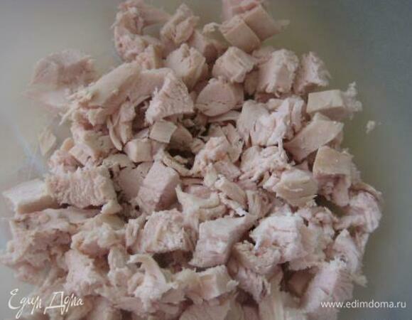 Берем отваренную куриную грудку, отделяем филе от кости. Филе произвольно нарезаем и отправляем в бульон. Продолжаем варить на среднем огне.