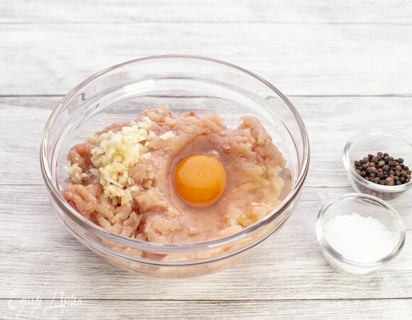 Добавьте яйцо, измельченный чеснок, соль и перец.