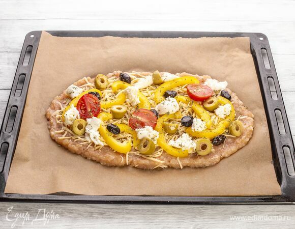 Болгарский перец нарежьте соломкой, черри — пополам, маслины — колечками, моцареллу порвите на мелкие кусочки. Все выложите на пиццу. Посыпьте прованскими травами. Запекайте пиццу в духовке при 200 °С 15 минут.