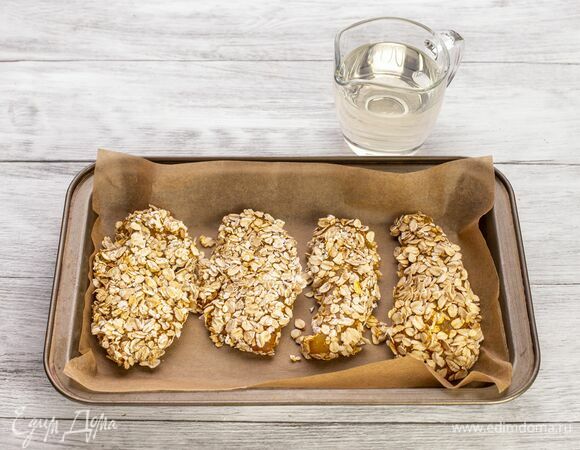 Противень застелите пекарской бумагой и сбрызните небольшим количеством растительного масла. Выложите курицу. Запекайте в духовке при 200 °С около 20–25 минут.