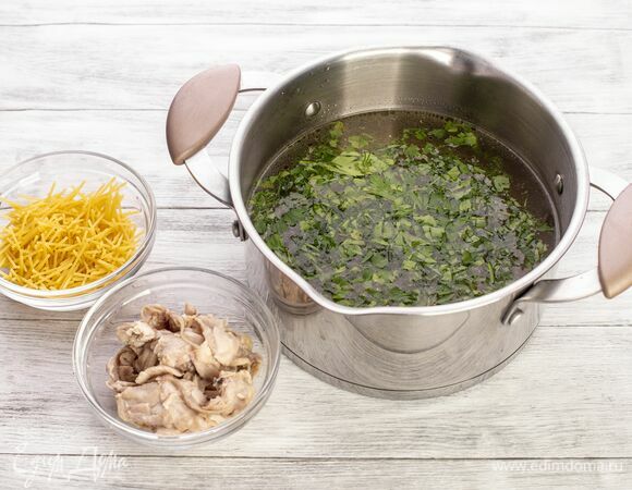 Достаньте курицу и отделите мясо от костей. Полученный бульон процедите через сито. Мясо курицы отправьте обратно в процеженный бульон. Добавьте мелко поломанные спагетти, затем — соль и измельченную зелень. Варите суп до готовности макарон.