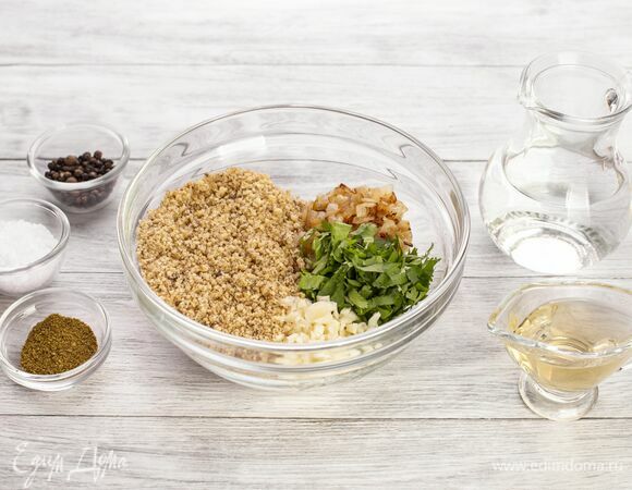 Займитесь соусом. Измельчите орехи в блендере. Лук, нарезанный кубиком, обжарьте на растительном масле.<br />
В большую чашу выложите орехи, жареный лук, мелко порубленную кинзу. Добавьте соль, перец, измельченный чеснок, хмели-сунели и уксус. Все хорошо перемешайте, постепенно вливая воду. Масса должна быть однородной и слегка густой. <br />
Поставьте соус в холодильник на 30 минут.