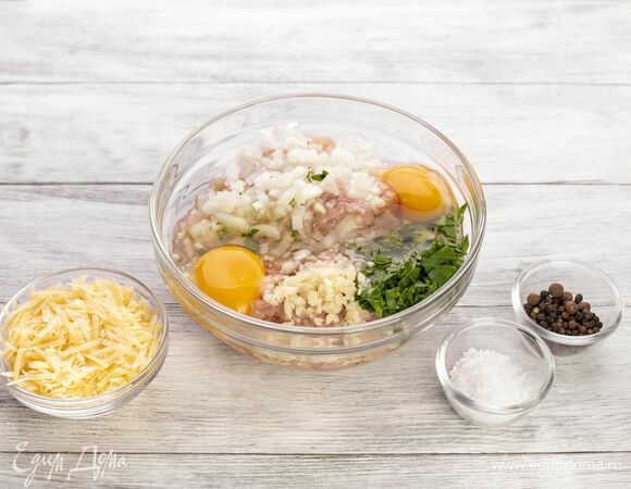Добавьте натертый сыр, яйца, измельченные чеснок и лук, а также нарезанную петрушку, соль, перец. Перемешайте.