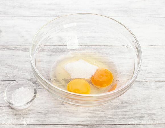 Приготовьте тесто для блинов. Взбейте яйца с солью и сахаром.
