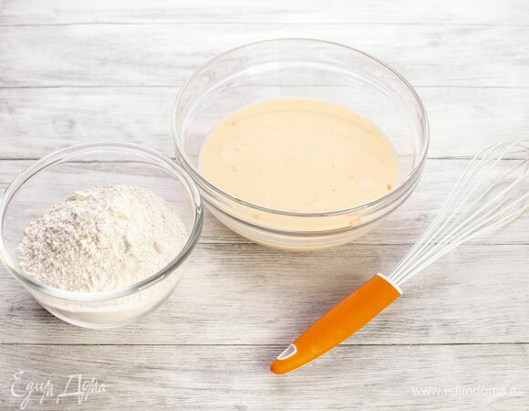 Влейте молоко, перемешайте. Постепенно добавьте муку.