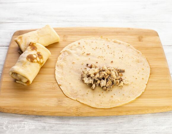 На каждый блин выложите ложку начинки и сверните конвертом. Готовые конвертики слегка обжарьте с двух сторон на сковороде с растительным маслом.