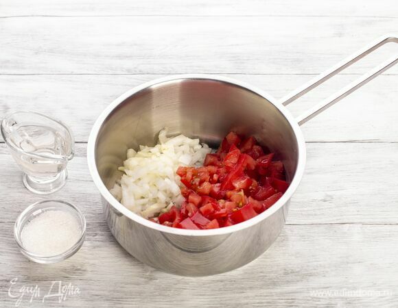 Приготовьте кетчуп. В сотейник поместите мелко нарезанные помидоры, измельченный лук, сахар и уксус. Тушите на небольшом огне 30 минут, помешивая.