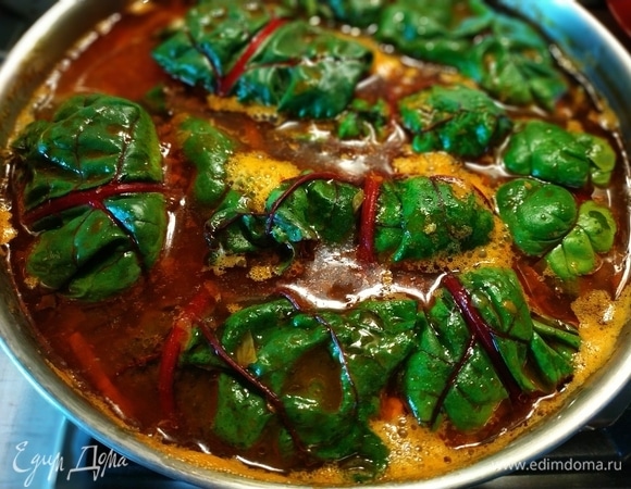 В обжаренные овощи налить воды, отрегулировать соль, слоями выложить голубцы и поставить их вариться на 40–45 мин.