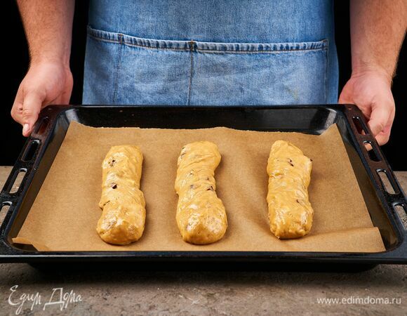 Смачивая руки водой, разделите тесто на три части и раскатайте продолговатые батоны шириной примерно 3 см. Выложите их на противень с пергаментной бумагой на небольшом расстоянии друг от друга и поставьте в духовку при 180 °C на 20 минут.