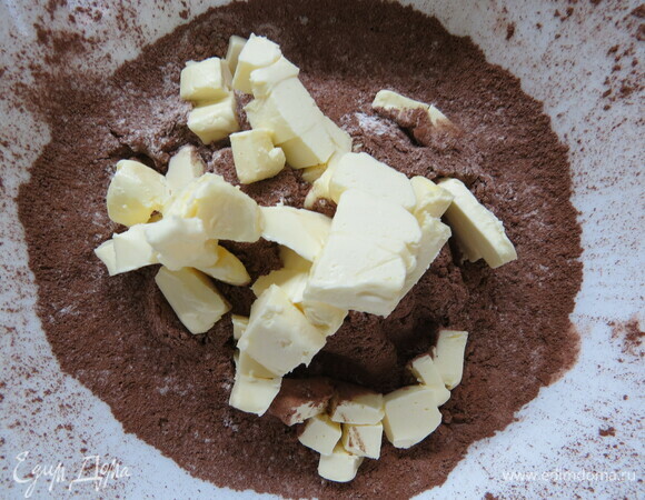 Для теста смешиваем в миске муку, сахарную пудру, какао и соль. Добавляем охлажденное и нарезанное кубиками сливочное масло и растираем смесь в крошку.