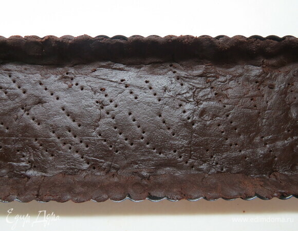 Духовку разогреваем до 200°C. Застилаем форму бумагой для выпечки или смазываем маслом и посыпаем мукой. Раскатываем охлажденное тесто в круг, затем переносим его и выкладываем в форму, делая бортики. Тесто в форме убрать на 30 минут в холодильник. Затем в течение 10 минут подпечь в духовке.