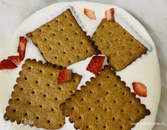 На дно формы выкладываем несколько крекеров, сверху смазываем кремом. Поверх крема выкладываем нарезанную на небольшие кубики клубнику.