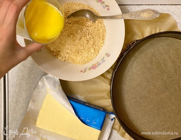 Печенье измельчить в крошку. Смешать с растопленным маслом. Постепенно наливайте и перемешивайте масло. Может потребоваться больше или меньше.