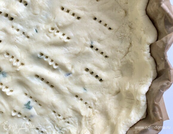 Форму диаметром примерно 25 см застелите пергаментом до верха и смажьте мягким сливочным маслом (примерно 15 г). Распределите равномерно тесто, сделайте бортики до верха и проткните вилкой по всей площади. Выпекайте в разогретой духовке при 200°C около 25 минут.