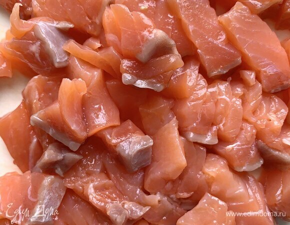 Слабосоленую красную рыбу разрежьте на кусочки 2 х 2 см. Разрезайте поперек волокон — так легче достать косточки.