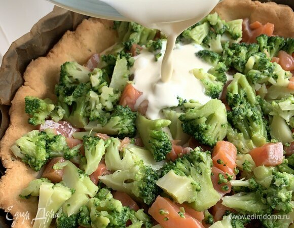 Достаньте песочную основу, выложите кусочки красной рыбы, броколли и залейте сверху сливочной начинкой. Выпекайте в разогретой духовке при 180°C примерно 30 минут. Подавать киш можно как теплым, так и холодным.