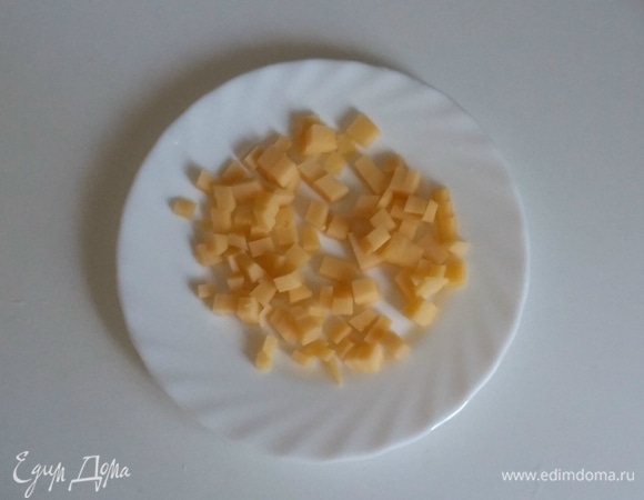Сыр нарезать пластинками, а затем каждую пластинку нарезать на кубики.
