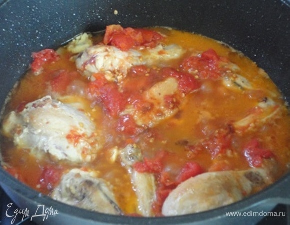 Вернуть к колбасе кусочки курицы, влить вино, добавить помидоры, чеснок, соль по вкусу и бульон. Поставить на средний огонь, довести до кипения и уменьшить огонь до минимума. Тушить 40 минут.