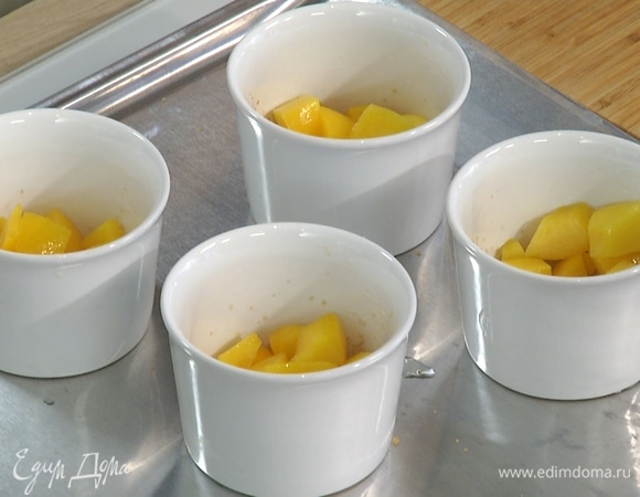 Керамические формочки смазать растительным маслом, дно присыпать коричневым сахаром, разложить в них нарезанные персики и залить тестом.