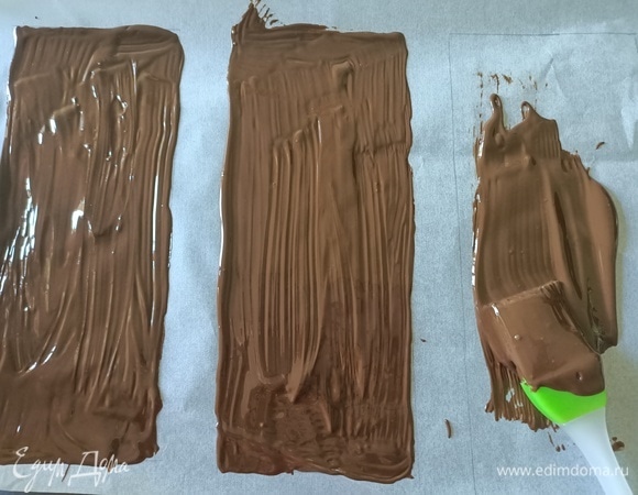 Шоколад растопить на водяной бане. На пергаментной бумаге нарисовать четыре прямоугольника, перевернуть бумагу и с помощью кисти нанести шоколад. Поместить бумагу с шоколадом в морозильную камеру для застывания.