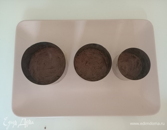 Дно формы застелить пергаментной бумагой. Выложить печенье, равномерно распределить и утрамбовать. Убрать в холодильник на 30 минут.