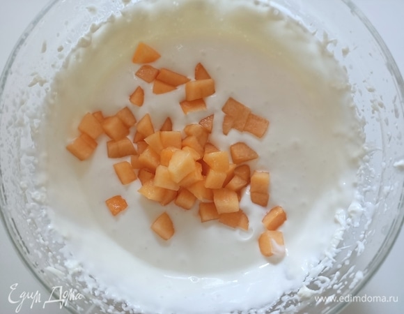 Очистить дыню, нарезать на мелкие кусочки, добавить в крем и перемешать.