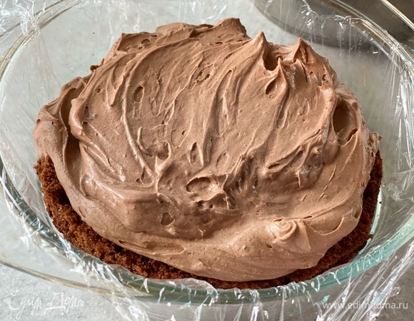 Сверху выложить вторую часть бисквита. Намазать торт кремом снаружи. Украсить тертым шоколадом.