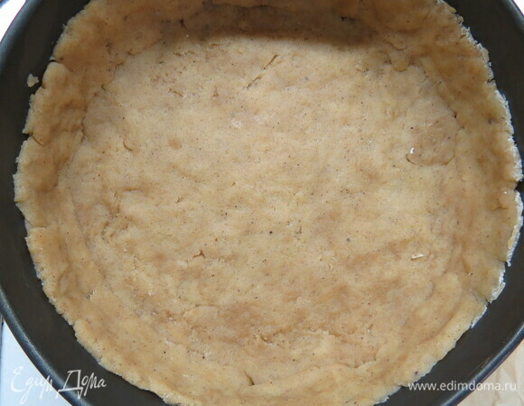 Дно формы диаметром 20 см застелить бумагой для выпечки, выложить тесто и руками распределить его по форме, сформировав бортики. Форму с тестом убрать в холодильник на 30 минут.