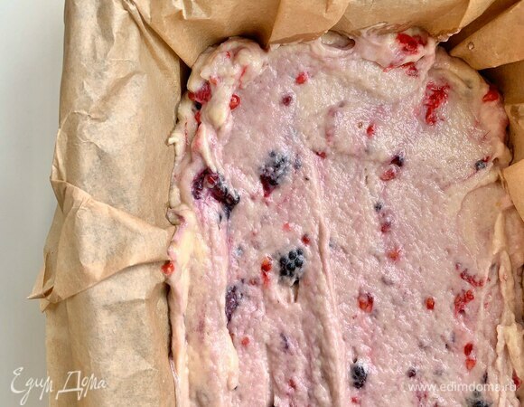 Выложите тесто в форму для кекса, застеленную пергаментом. Верх кекса аккуратно выровняйте лопаткой.