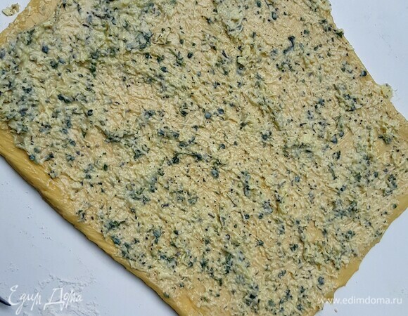 Тесто раскатать в прямоугольник и распределить всю начинку. Скрутить в плотный рулет.