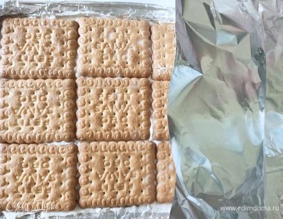 Сверху выложить печенье, предварительно окунув его в молоко. Накрыть форму фольгой и отправить в морозильную камеру минимум на 5 часов.