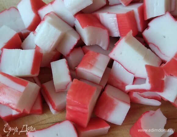 Нарезать крабовые палочки кубиком.