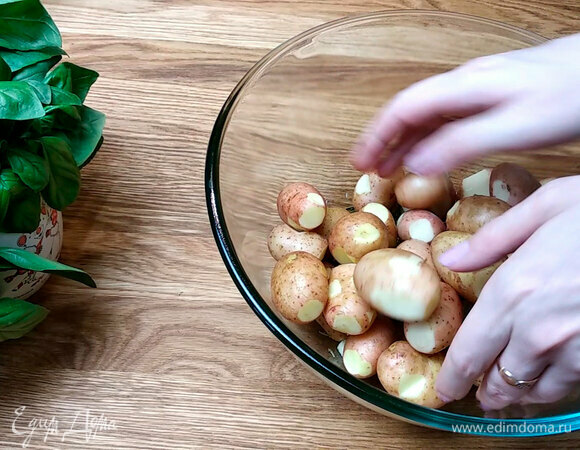В большую емкость вливаем растительное масло и добавляем чесночную смесь, все перемешиваем. Добавляем соль и черный перец по вкусу. Этой смесью покрываем весь картофель и оставляем на 5–10 минут, чтобы картофель полностью пропитался всеми пряностями.