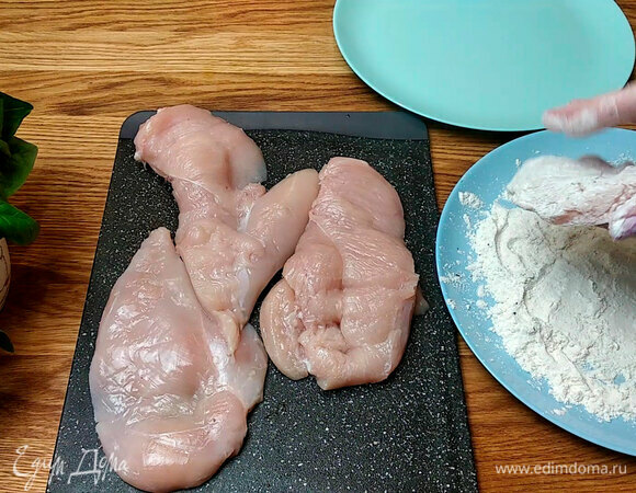 Куриное филе просушить и разрезать на две части. В муку добавить соль и перец, обвалять в ней филе.