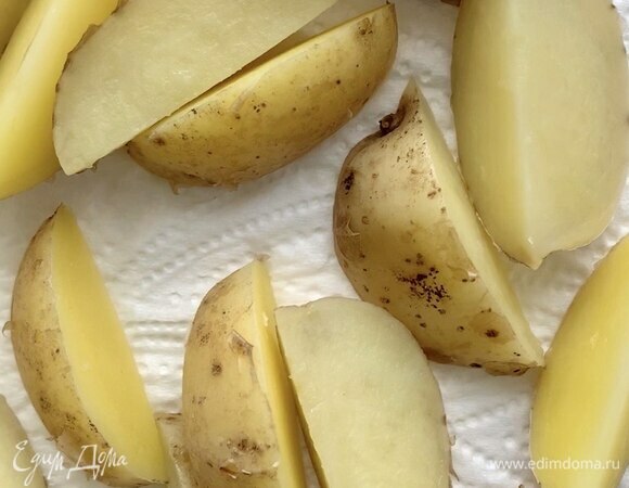 Положите картофельные дольки в кипящую воду и варите после закипания около 3 минут. Затем слейте воду с картошки, выложите дольки на бумажное полотенце и дайте им немного остыть.