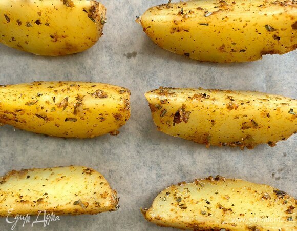 Противень застелите пергаментом, выложите дольки и запекайте в хорошо разогретой духовке при 210°C примерно 25–30 минут, до румяной корочки. Подавайте картошку теплой, идеально — со сметанно-чесночным соусом и травами. Приятного аппетита!