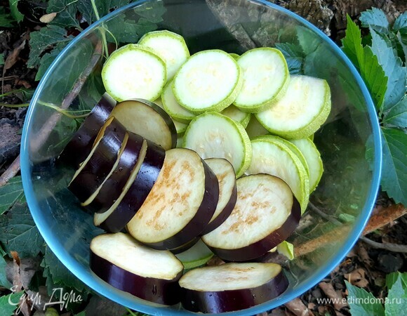 Тем временем кружочками нарезать баклажан и кабачок. Баклажан поместить в холодную соленую воду на 10 минут.